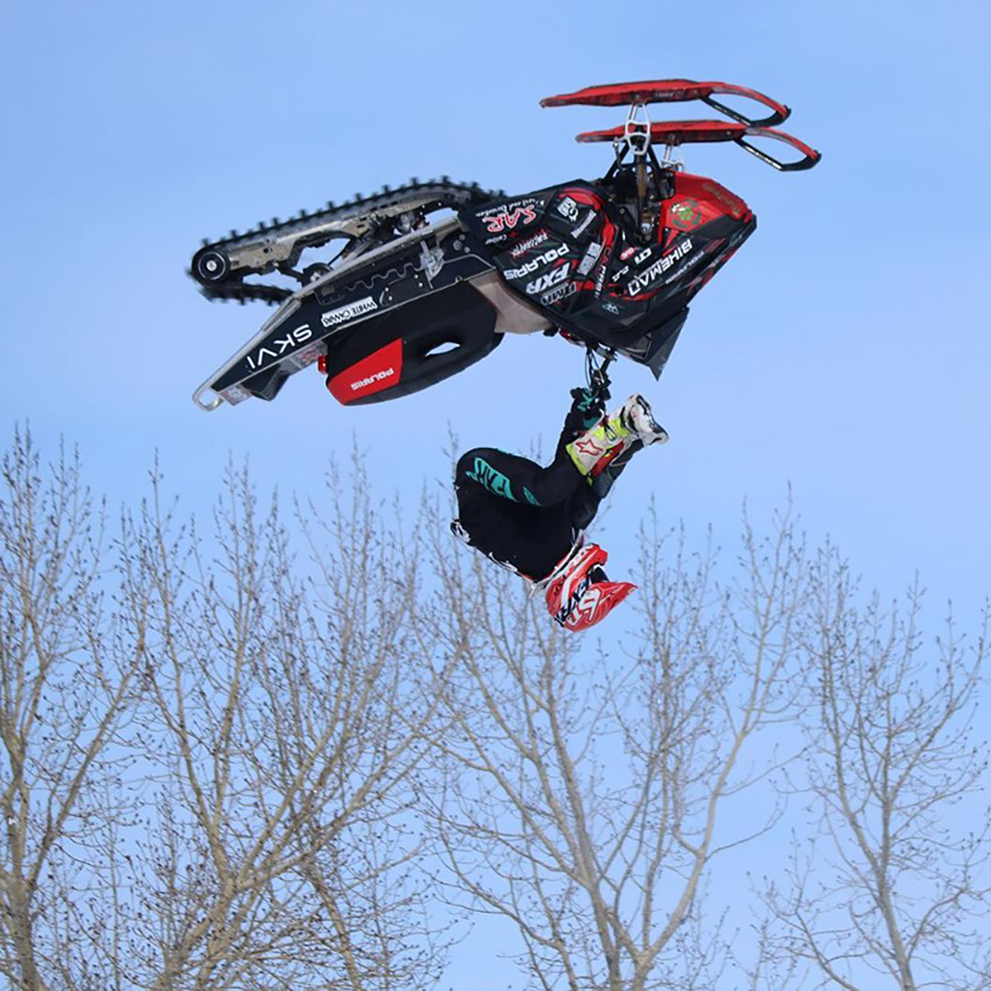 Josh Penner midair flip with custom red and black C&A Pro skis with black handles