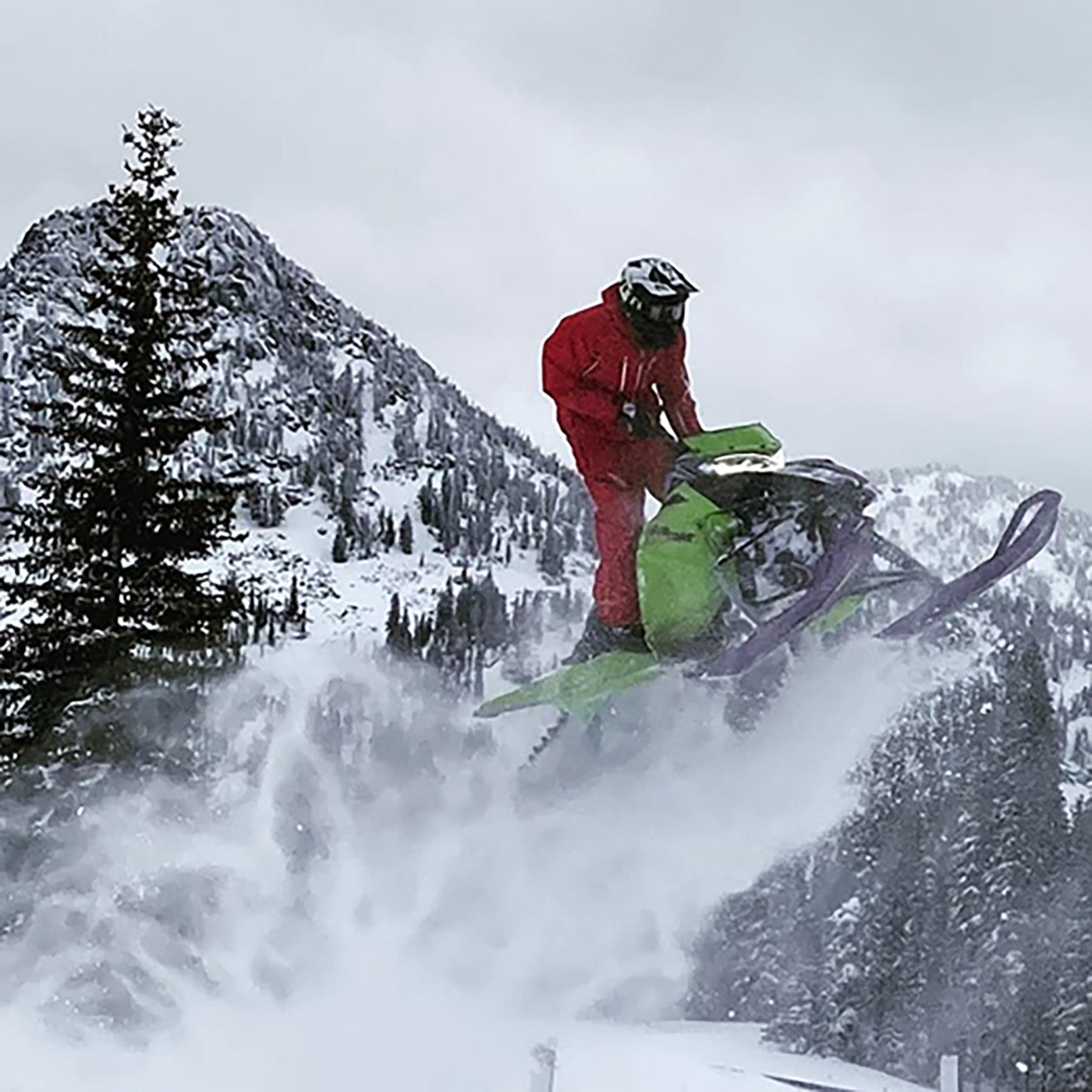Ryan Phillips midair sledding with all-black C&A Pro skis on snowmobile