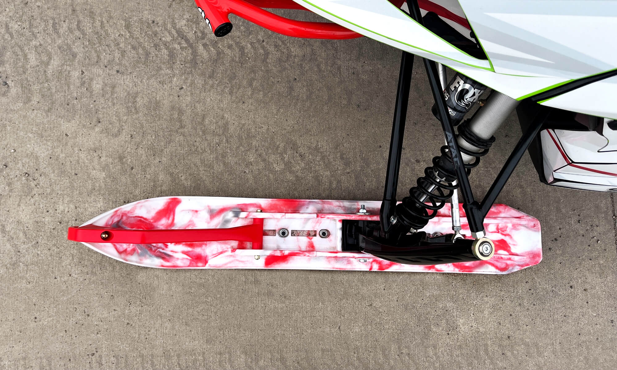 White, red and gray custom swirl C&A Pro XCS ski with red handle installed on Arctic Cat snowmobile