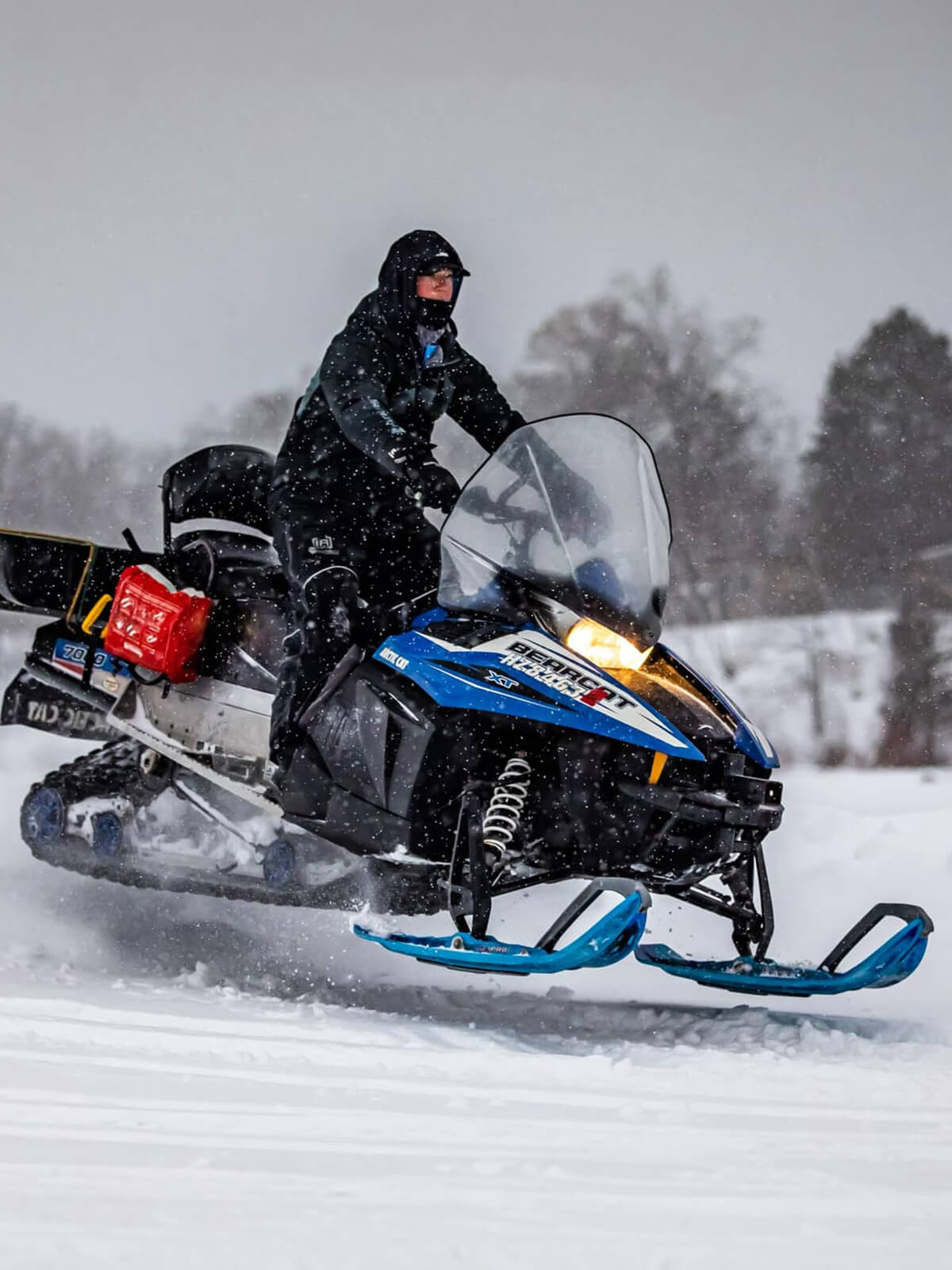Clam Ice Team member riding Arctic Cat Bearcat snowmobile with custom Sky Blue MTX skis from C&A Pro