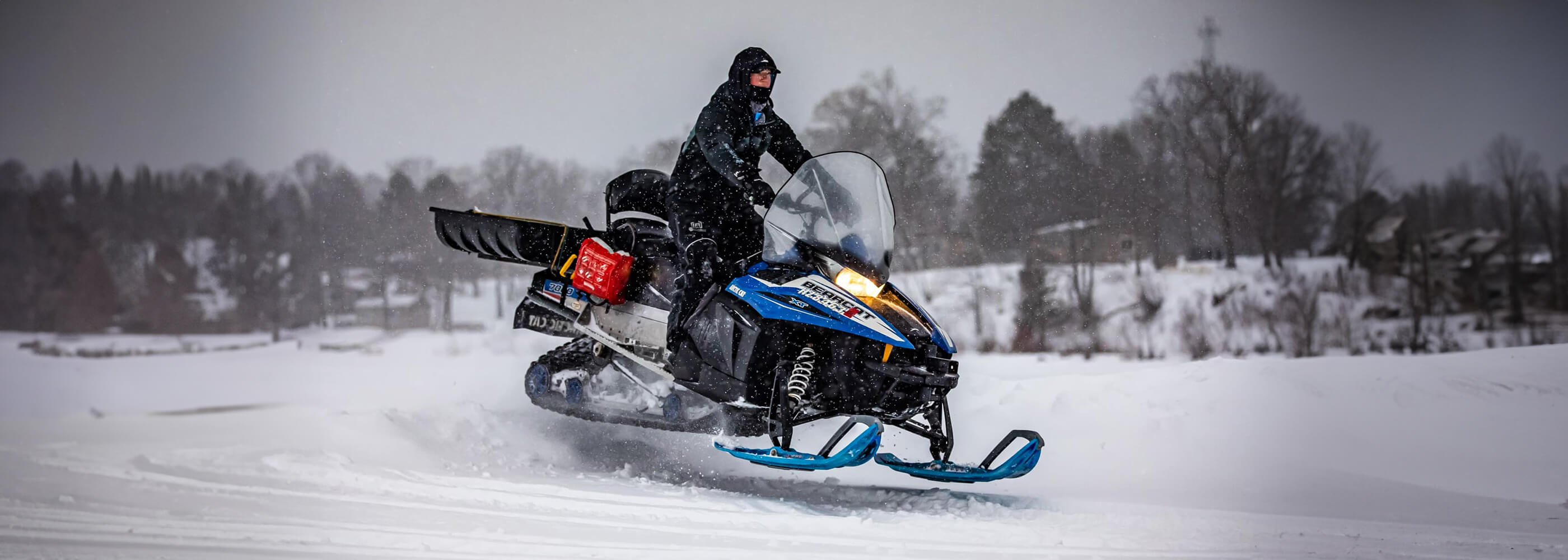 Clam Ice Team member riding Arctic Cat Bearcat snowmobile with custom Sky Blue MTX skis from C&A Pro