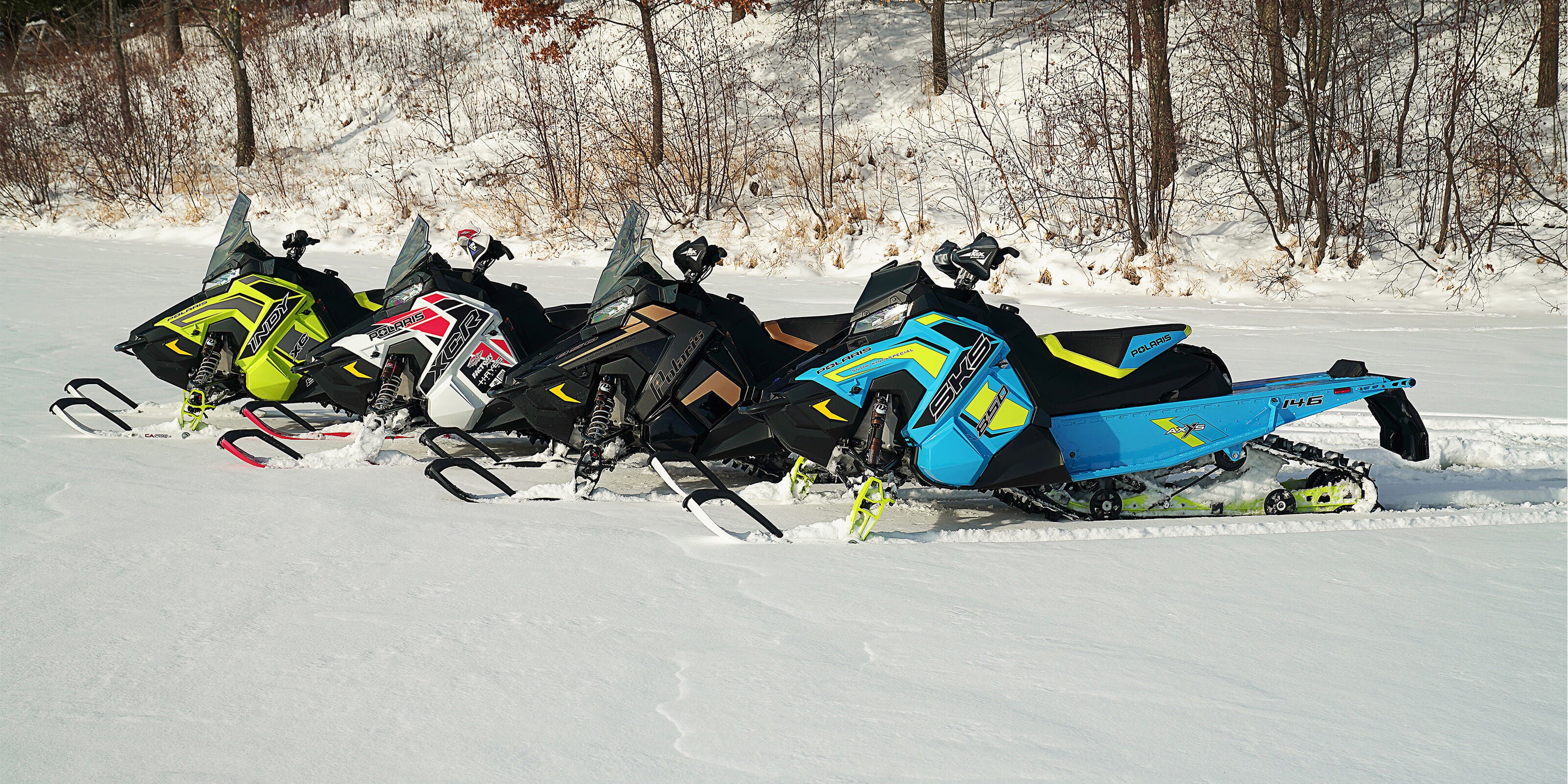 Polaris snowmobiles on a snowy trail equipped with C&A Pro Snowmobile Skis for trail riding.