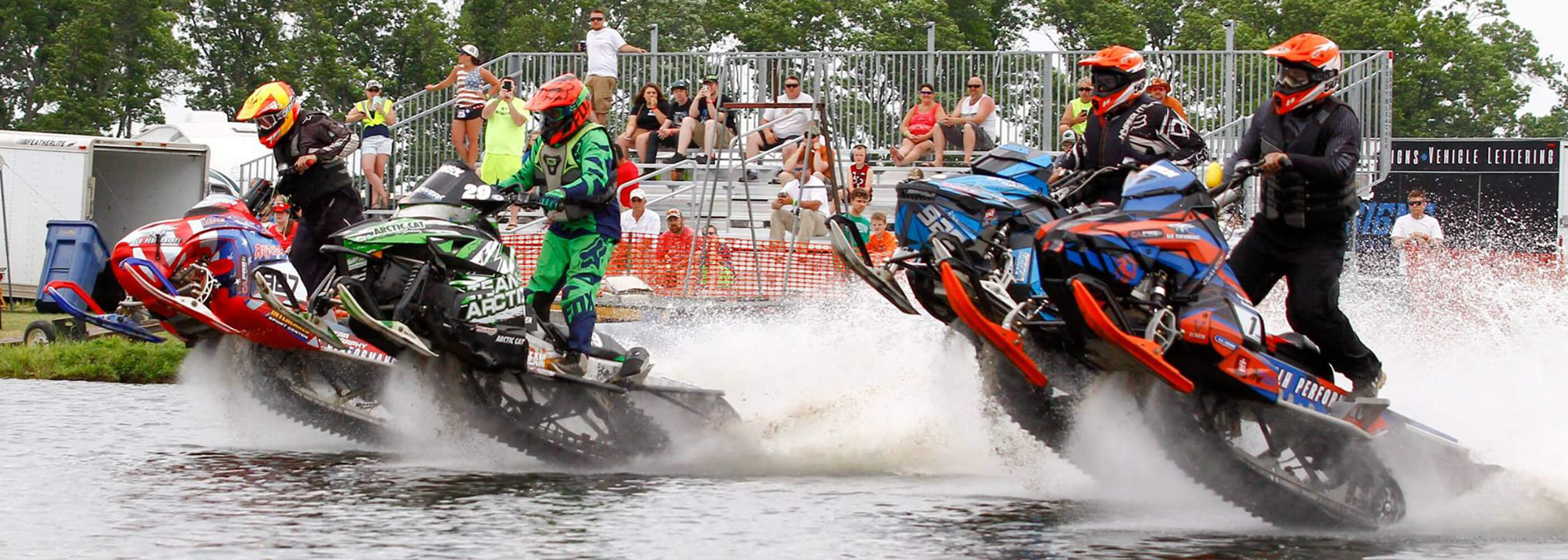 Group of professional watercross racers riding snowmobiles on the water at International Watercross Association event
