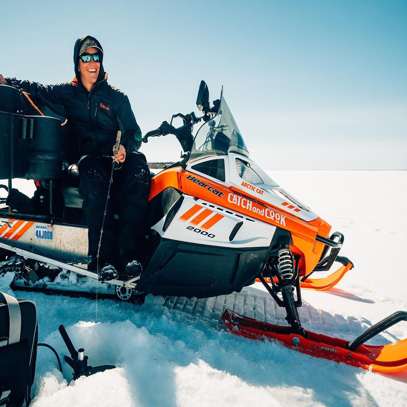 Influencer Jay Siemens sitting on snowmobile with orange C&A Pro skis